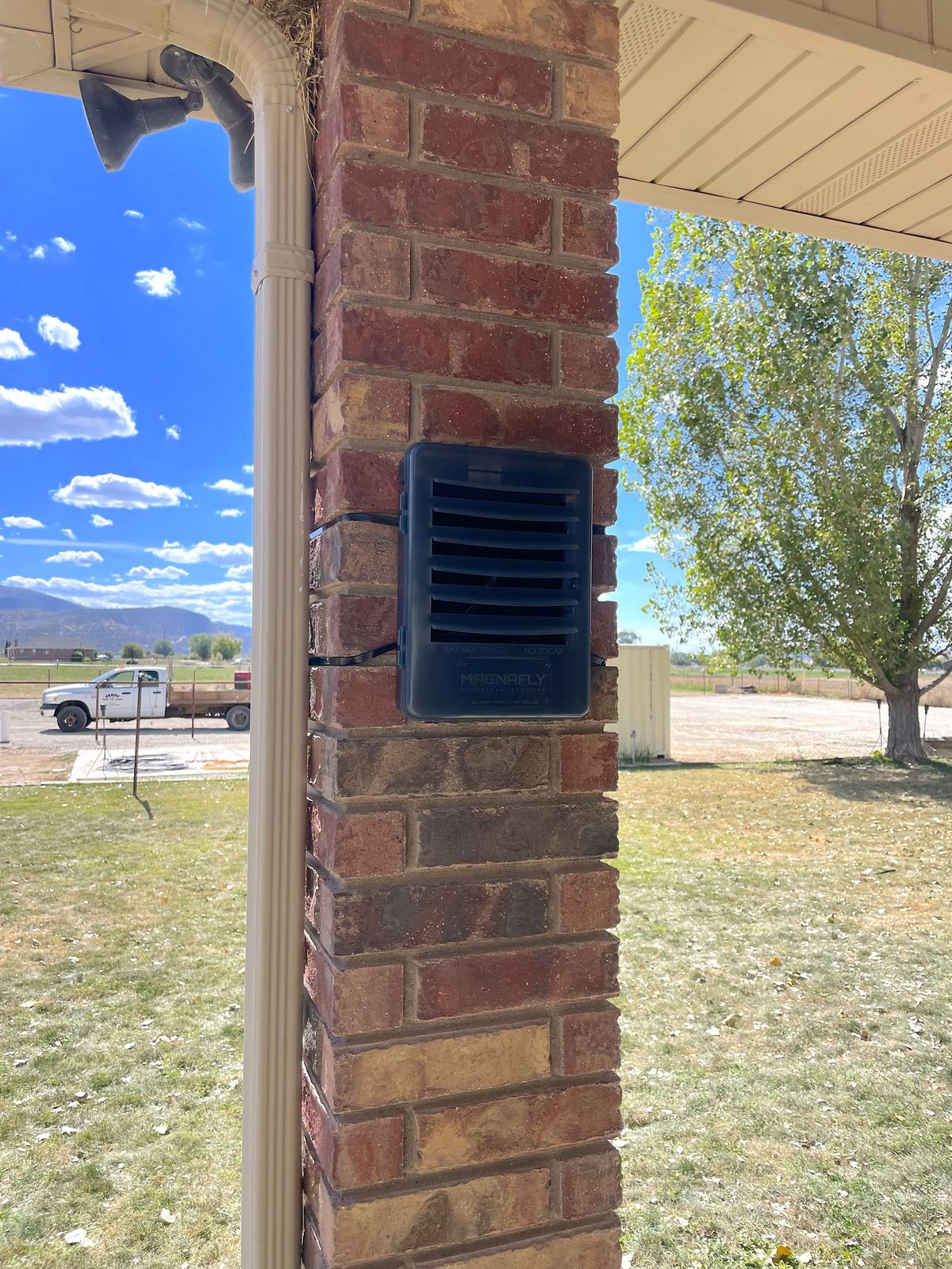 Magnafly baiting station mounted on an exterior brick pillar